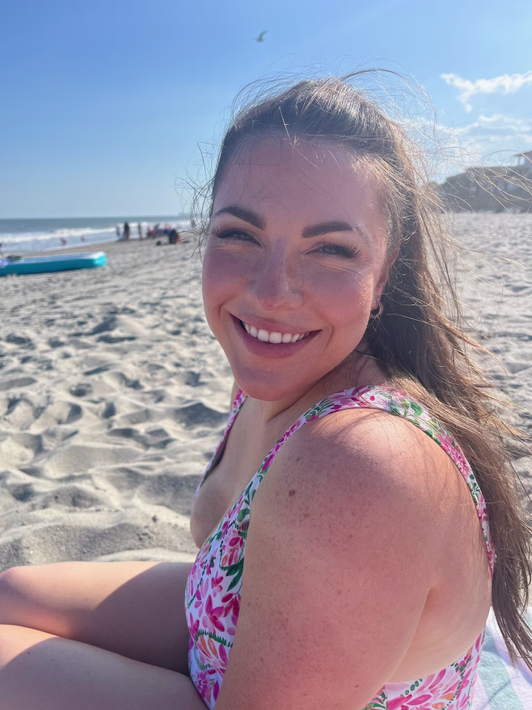 Erin sitting on the beach at Myrtle Beach with a smile on her face.